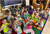 Students smiling, sitting together on the floor. thumbnail266403